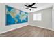 Spacious bedroom with wood-look flooring features a painted world map on the wall at 14200 W Larkspur Dr, Surprise, AZ 85379