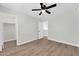Relaxing bedroom with wood-look flooring and ceiling fan and a view of an attached closet at 14200 W Larkspur Dr, Surprise, AZ 85379