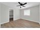 Bedroom with wood-look floors and ceiling fan features an adjoining closet with chandelier at 14200 W Larkspur Dr, Surprise, AZ 85379