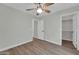 Relaxing bedroom with wood-look floors, ceiling fan, and an attached closet at 14200 W Larkspur Dr, Surprise, AZ 85379