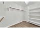Walk-in closet with built-in shelving and hanging rods, illuminated by a stylish chandelier at 14200 W Larkspur Dr, Surprise, AZ 85379