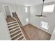 Open entryway featuring hardwood floors, high ceilings, natural lighting, and wooden staircase with iron railings at 14200 W Larkspur Dr, Surprise, AZ 85379