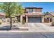 Two-story home featuring a tile roof, large driveway, and low maintenance desert landscaping at 14200 W Larkspur Dr, Surprise, AZ 85379