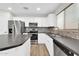 Well-lit kitchen with stainless steel appliances, granite counters, modern backsplash, and a breakfast bar at 14200 W Larkspur Dr, Surprise, AZ 85379