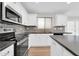 Bright kitchen boasts white cabinets, stainless appliances, granite counters and stylish backsplash at 14200 W Larkspur Dr, Surprise, AZ 85379