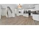 View of an open-concept floor plan showcasing the kitchen, living room and stairway at 14200 W Larkspur Dr, Surprise, AZ 85379