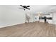Open concept living room with wood-look floors and a view into the adjacent kitchen at 14200 W Larkspur Dr, Surprise, AZ 85379