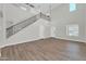 Bright living room showcasing high ceilings, wood-look floors, and an adjacent staircase at 14200 W Larkspur Dr, Surprise, AZ 85379
