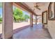 Covered patio showing the fan, lush trees, view of a big, green backyard at 14200 W Larkspur Dr, Surprise, AZ 85379
