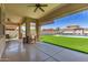 Inviting covered patio with an outdoor grill and bar area, overlooking a lush, landscaped backyard and pool at 14552 S 182Nd Dr, Goodyear, AZ 85338