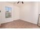 Bright bedroom with a ceiling fan and large window view of bougainvillea bush at 14552 S 182Nd Dr, Goodyear, AZ 85338