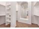Walk-in closet features arched mirror, built-in shelves, and ample space for storage and organization at 14552 S 182Nd Dr, Goodyear, AZ 85338