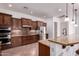 Spacious kitchen features dark wood cabinetry, stone backsplash, and stainless steel appliances at 14552 S 182Nd Dr, Goodyear, AZ 85338