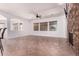 Open-concept living room with a brick fireplace, ample natural light and tile floors at 14552 S 182Nd Dr, Goodyear, AZ 85338