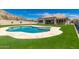 A stunning pool and beautifully landscaped backyard featuring a built-in bar, and lush artificial grass at 14552 S 182Nd Dr, Goodyear, AZ 85338