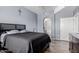 Bright bedroom with a large bed, attached bath, and an arched entryway at 14575 W Mountain View Blvd # 11220, Surprise, AZ 85374