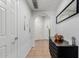 Neutral hallway with an arched doorway, wood decor, and a dark wood storage cabinet at 14575 W Mountain View Blvd # 11220, Surprise, AZ 85374