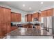 Well-equipped kitchen featuring stainless steel appliances and granite countertops with dark wood cabinetry at 14575 W Mountain View Blvd # 11220, Surprise, AZ 85374