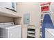Functional laundry area equipped with a washer, dryer, and storage shelves at 14575 W Mountain View Blvd # 11220, Surprise, AZ 85374