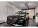 Spacious garage with a modern black vehicle parked inside, showcasing functionality and storage at 14823 N 29Th Ave, Phoenix, AZ 85053