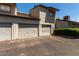 View of attached garages, lush green shrubs, and asphalt driveway at 15407 N 2Nd St, Phoenix, AZ 85022
