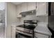 Close up of stainless steel oven range with overhead vent and bright countertops at 15407 N 2Nd St, Phoenix, AZ 85022