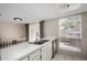 Bright kitchen featuring a stainless steel sink, white countertops, and an adjacent dining area with backyard views at 15407 N 2Nd St, Phoenix, AZ 85022