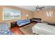 Cozy bedroom featuring multiple beds, wood floors, a ceiling fan, and a large window at 17819 N 46Th Dr, Glendale, AZ 85308