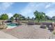 Large backyard featuring a pool, lush landscaping, firepit, and a manicured golf course at 17819 N 46Th Dr, Glendale, AZ 85308