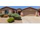 Charming home exterior features desert landscaping, a two-car garage, and neutral color palette at 18072 W Paradise Ln, Surprise, AZ 85388