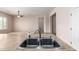 Modern kitchen featuring a stainless steel sink and an open floor plan to a spacious living area at 18072 W Paradise Ln, Surprise, AZ 85388