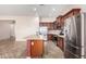 Open kitchen with stainless appliances, center island, tile backsplash, and dark wooden cabinetry at 18072 W Paradise Ln, Surprise, AZ 85388