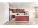Modern kitchen with stainless appliances, an island with sink, dark wood cabinets, and great lighting at 18072 W Paradise Ln, Surprise, AZ 85388