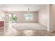 Spacious living room with plush carpeting, ceiling fan, and bright natural light from sliding glass doors at 18072 W Paradise Ln, Surprise, AZ 85388