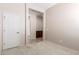 Room featuring carpet, an adjoining doorway, and a view to hallway cabinets at 18072 W Paradise Ln, Surprise, AZ 85388