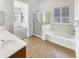 Bright bathroom featuring double sinks, a soaking tub, and a glass-enclosed shower at 18207 W Marshall Ln, Surprise, AZ 85388