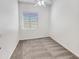 Clean, carpeted bedroom with white walls, a ceiling fan, and a window with blinds at 18207 W Marshall Ln, Surprise, AZ 85388