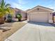 Home with a two-car garage, desert landscaping, and a well-maintained lawn at 18207 W Marshall Ln, Surprise, AZ 85388