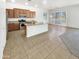 Well-lit kitchen with wooden cabinets, stainless steel appliances, an island, and tiled flooring at 18207 W Marshall Ln, Surprise, AZ 85388