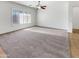 Spacious living room with carpet flooring, a ceiling fan, white walls, and shutters at 18207 W Marshall Ln, Surprise, AZ 85388