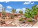 Desert landscaped backyard with gravel, tile pathways, lush greenery, and charming water features creating a serene outdoor oasis at 18482 W Marconi Ave, Surprise, AZ 85388