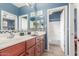 Bathroom with double sinks, tiled backsplash and cherry wood cabinets at 18482 W Marconi Ave, Surprise, AZ 85388