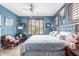 Bright bedroom featuring a ceiling fan, window with shutters and blue accent wall at 18482 W Marconi Ave, Surprise, AZ 85388