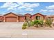 Exterior shot of a well-maintained house with a three-car garage and desert landscaping at 18482 W Marconi Ave, Surprise, AZ 85388