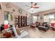 Open-concept living room showing tile floors, ceiling fan, large shelving unit, and recessed lighting at 18482 W Marconi Ave, Surprise, AZ 85388