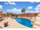 Beautiful private swimming pool surrounded by landscaping and a clear blue sky at 18482 W Marconi Ave, Surprise, AZ 85388