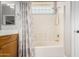 Bright bathroom featuring a tub-shower combination with decorative tile, a vanity, and a modern glass block window at 18775 E Seagull Dr, Queen Creek, AZ 85142