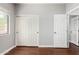 Bedroom featuring a pair of doors, hardwood floors, and light-colored walls with a large window at 18775 E Seagull Dr, Queen Creek, AZ 85142