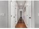 Hallway featuring dark hardwood floors, white trim, and multiple doors along the wall at 18775 E Seagull Dr, Queen Creek, AZ 85142