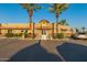 Community clubhouse entrance with palm trees, manicured landscaping, and convenient parking at 19942 N 108Th Ave, Peoria, AZ 85373